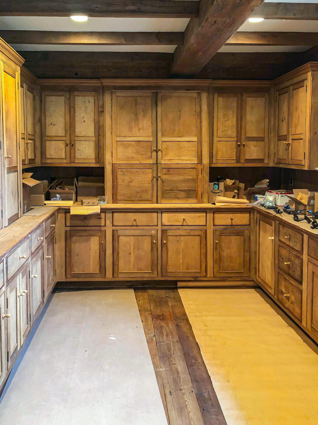 Installed antique-finish wood pantry cabinets, full view