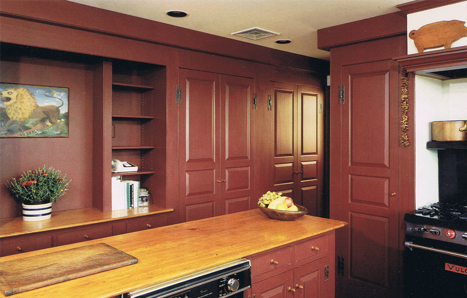 Dark red full kitchen cabinet wall with open shelving and butcher block island