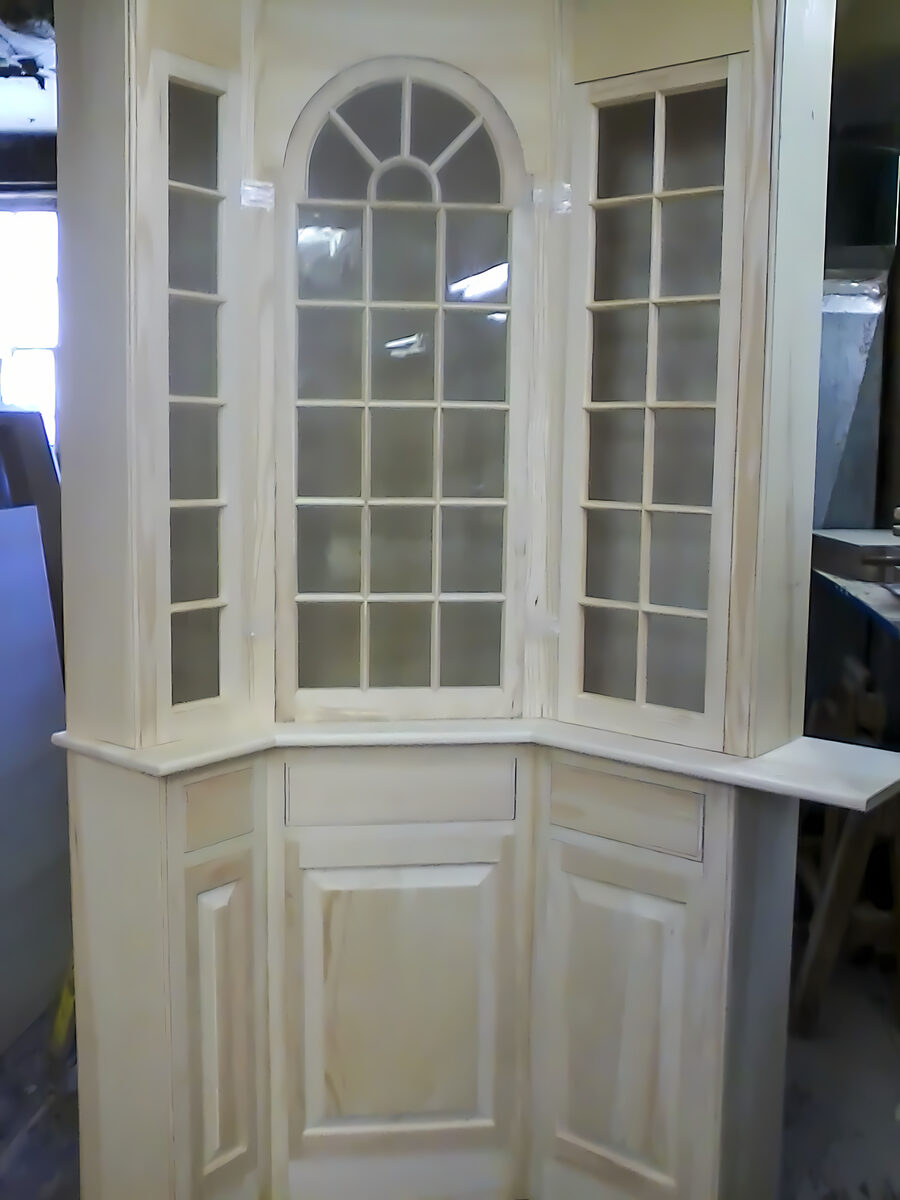White glazed corner cabinet with arched upper door and raised panel lower sections
