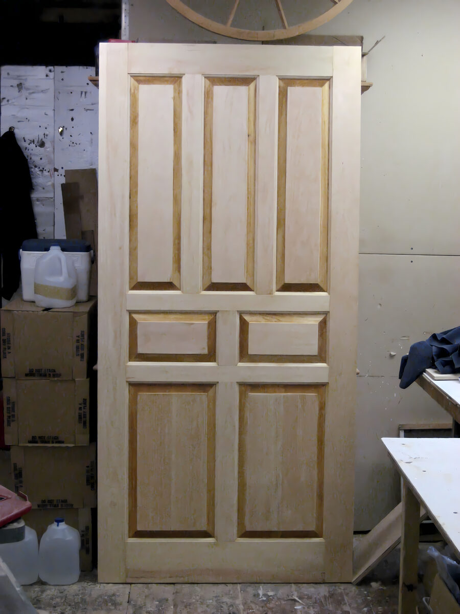 Dark wood full-height raised panel installation, colonial interior