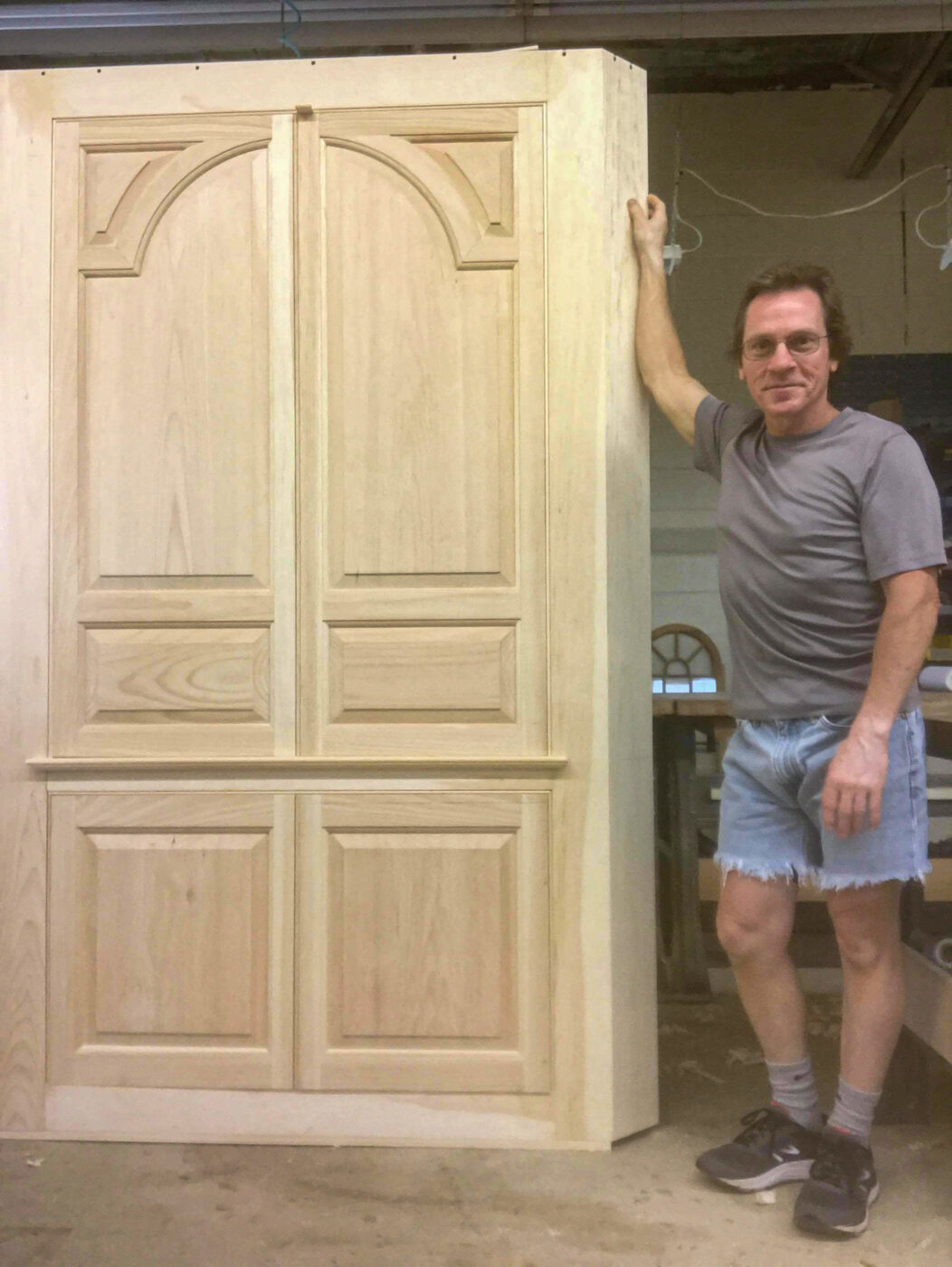 Completed entertainment center corner cupboard with craftsman standing for scale