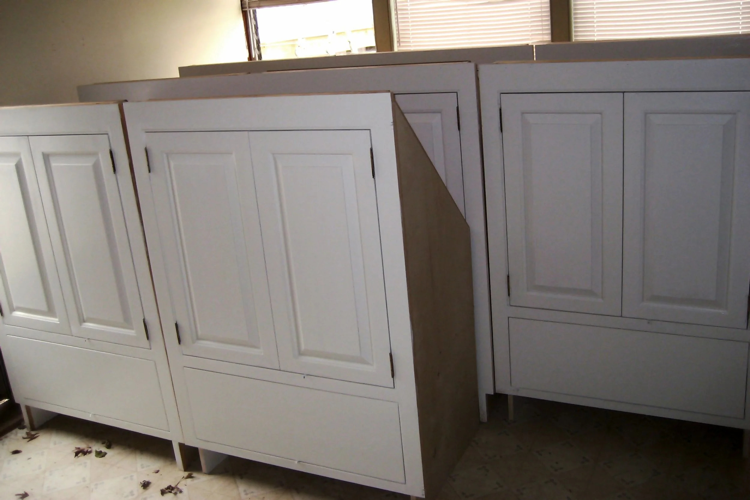 Tall natural pine cupboard pair with raised panel doors, shop view