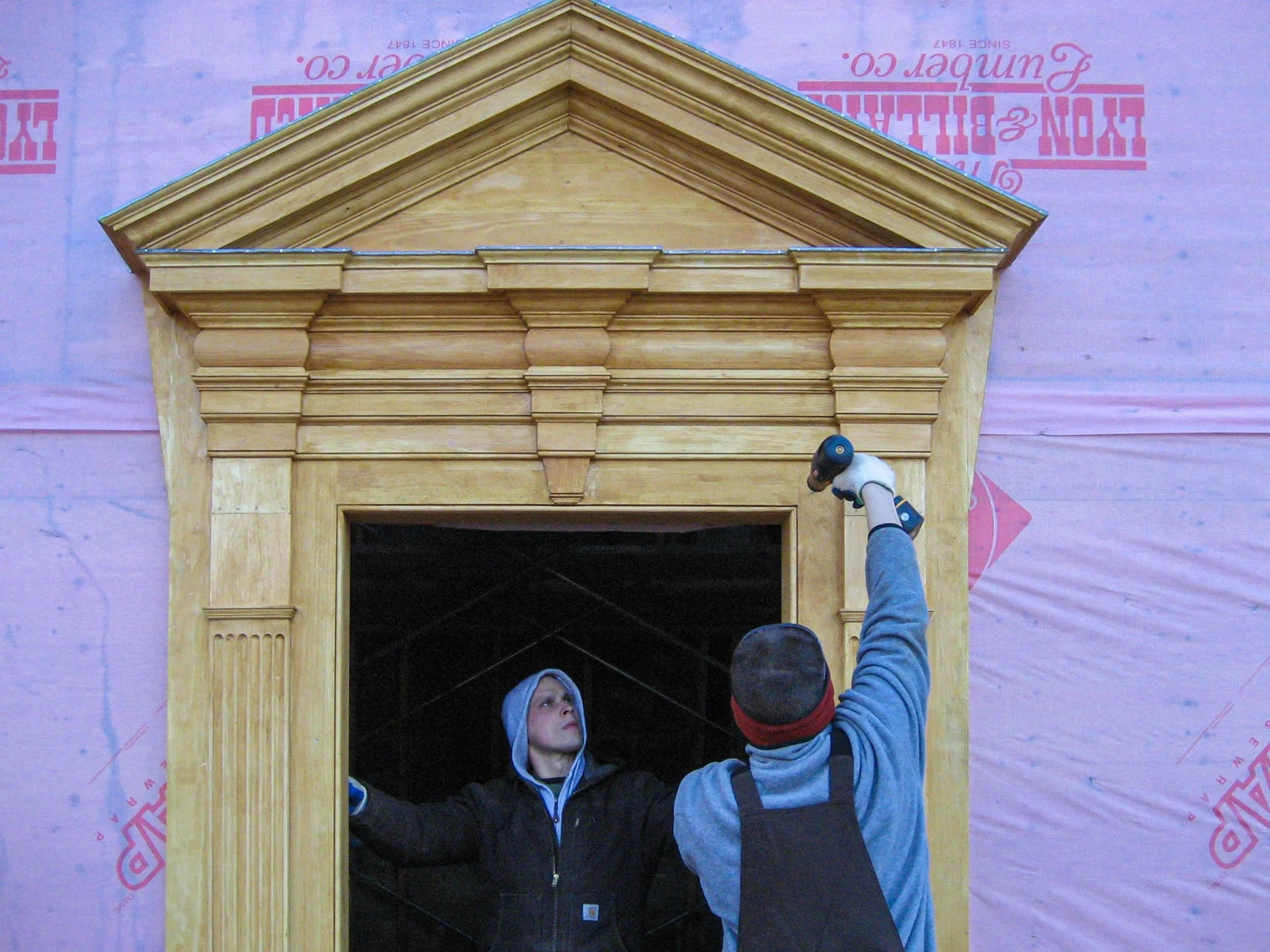 Installed triangular pediment entryway on colonial home exterior