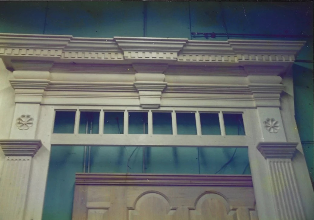 Entryway with transom and pilasters, painted cream, installed exterior view