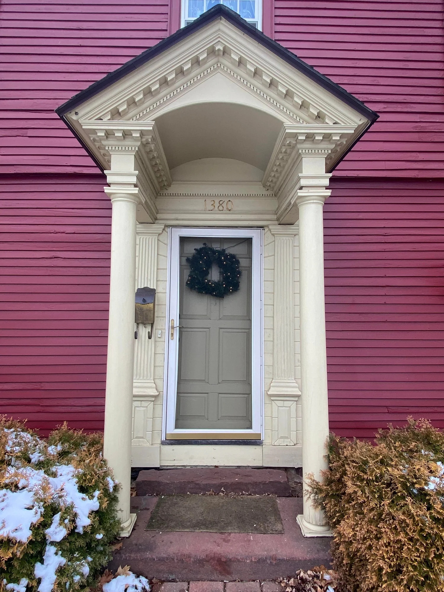 Raw wood pilastered entryway close-up showing cornice and capital detail
