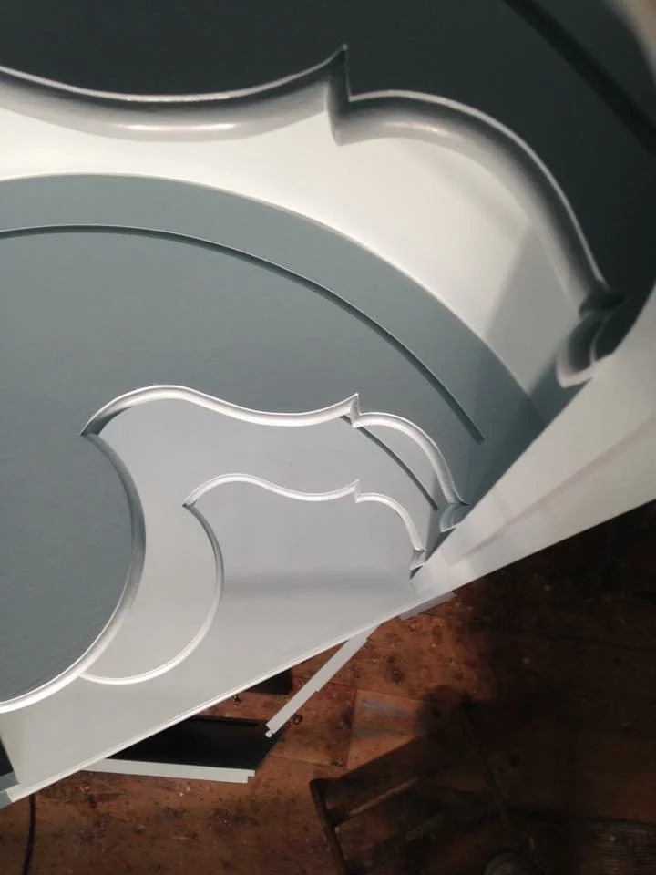 Interior painted crown corner at coved ceiling junction looking up, pendant light visible