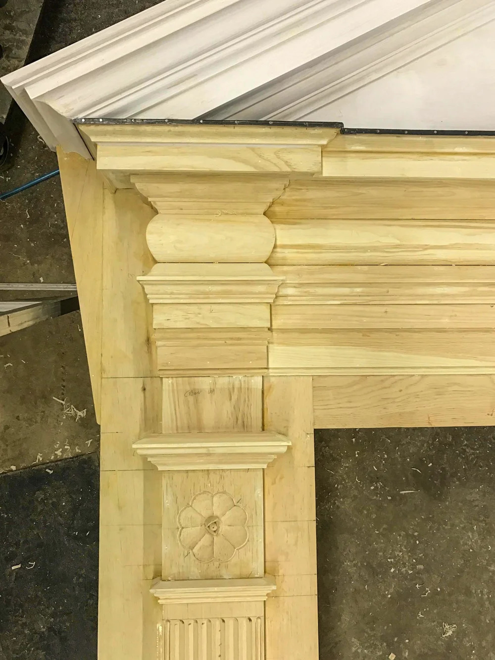 Hand-carved flower and rosette ornament in raw pine, applied panel ornament