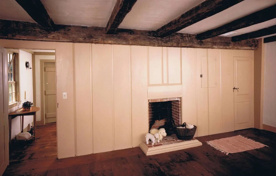 Colonial room with dark red barn-red painted paneling and oil portrait on wall