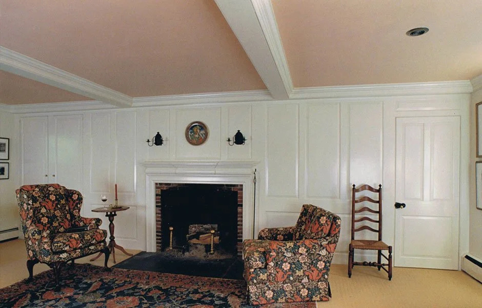 Blue painted full-wall paneling with fireplace, colonial room with sofa