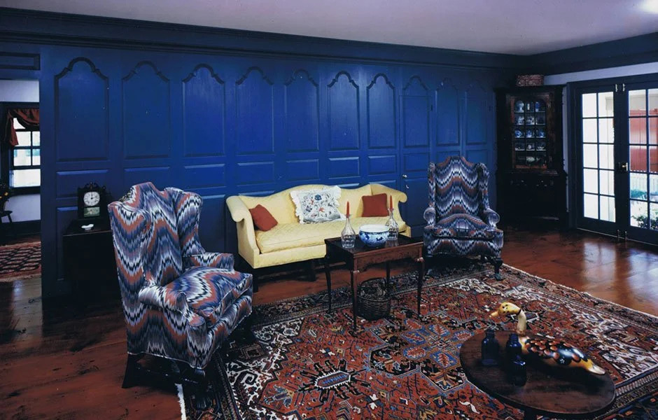 Terracotta orange painted paneling with fireplace and period chair