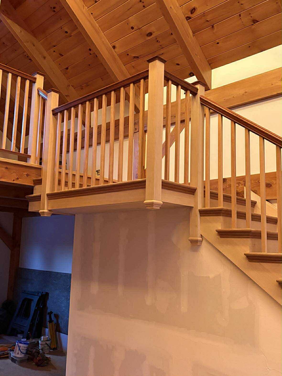 Completed custom staircase with dark stained treads and wood railing