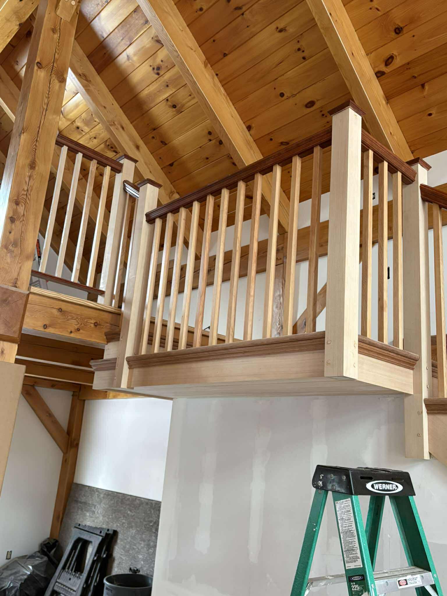 Completed staircase looking upward, dark stained treads with light wood balusters