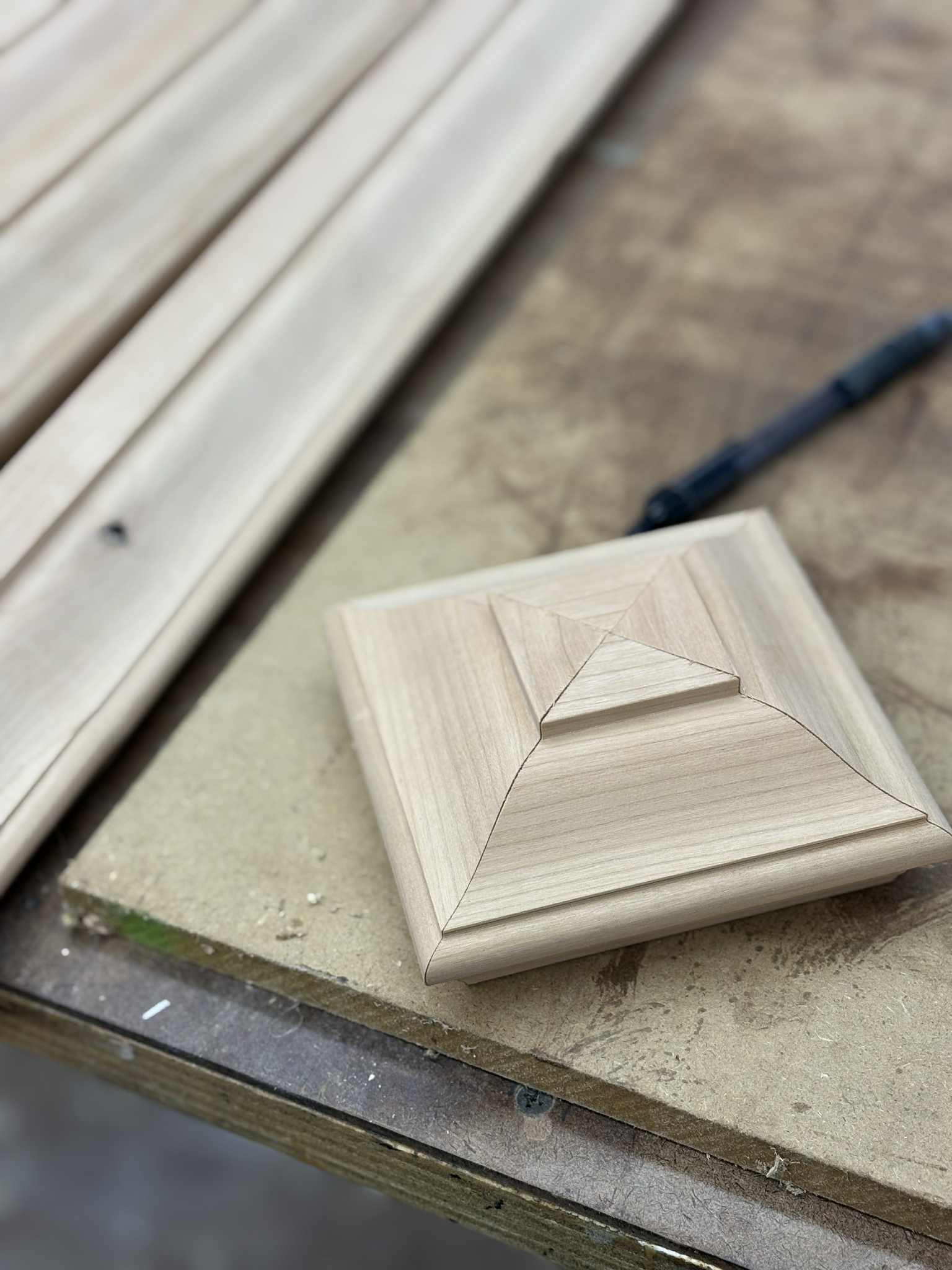 Newel post cap plinth detail, raw pine — precision-cut square moulding
